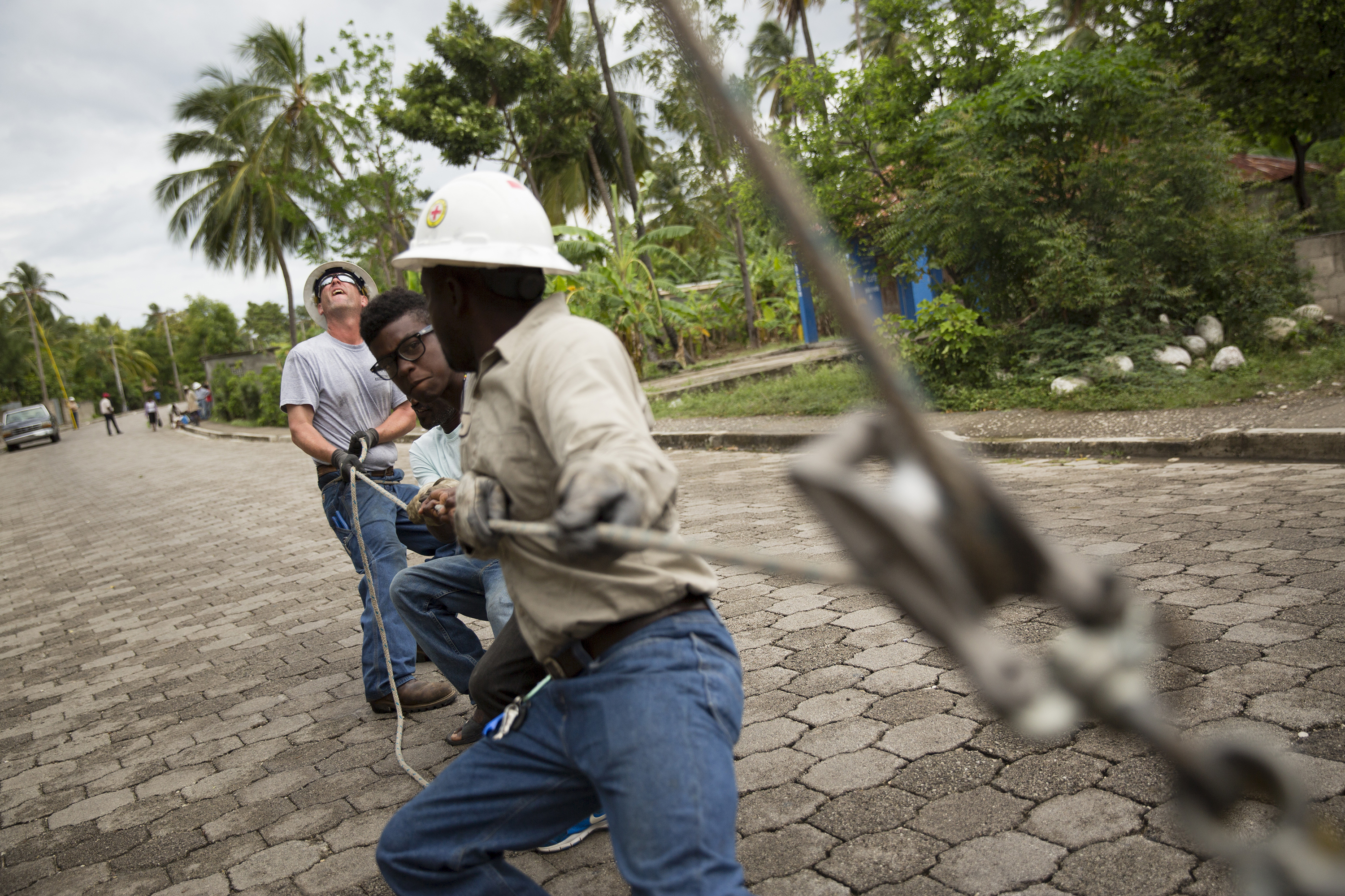 Co-op volunteer linemen from Kentucky work with Haitian linemen to bring electricity to Coteaux, Haiti. (Photo courtesy Garret Hubbard/NRECA International)