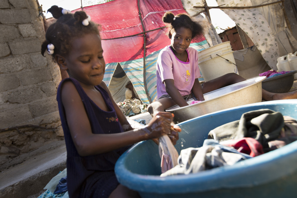 Without washing machines, a regular chore for young Haitian girls is to wash clothes by hand. (Photo By: Garrett Hubbard)