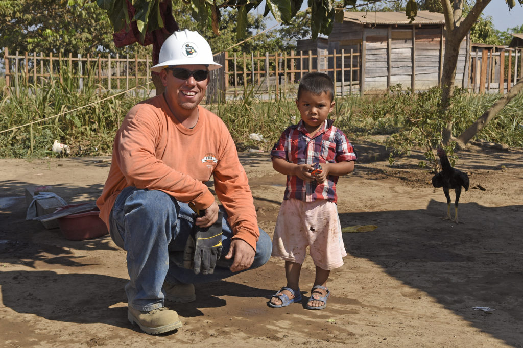 Tom Golder and a child from the village of Dos de Junio, Bolivia. (Photo by Jim McCarty)