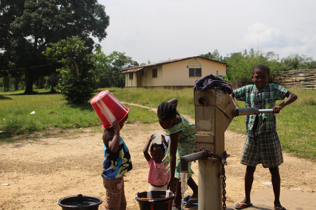 Without running water in their homes, the residents of Totota, Liberia, must hand pump water from a community well. (Photo courtesy NRECA International)